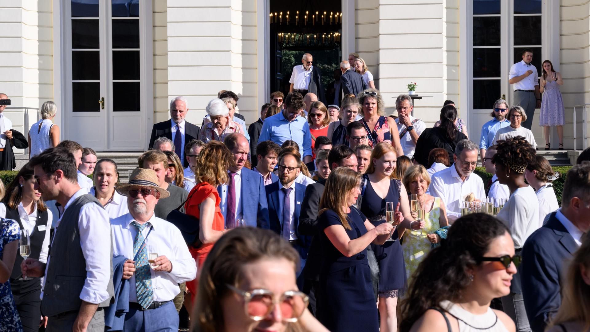 Zahlreiche Gäste gehen beim Bürgerfest von Bundespräsident Steinmeier durch das Schloss in den Park von Schloss Bellevue.