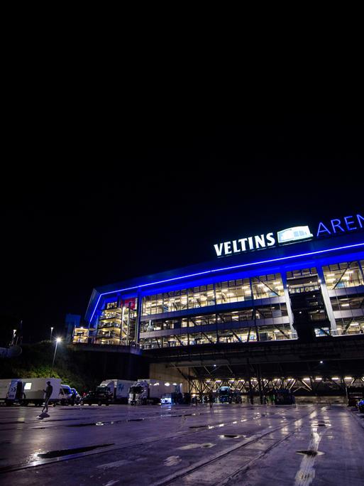 Die Schalker Veltins-Arena in der Nacht, in Fenstern ist Licht zu sehen. 