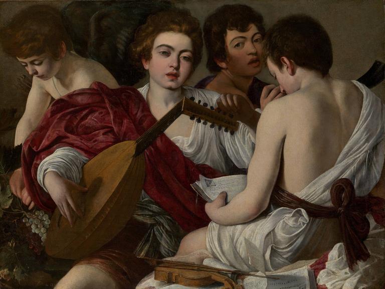 Gemälde "Die Musiker" von Caravaggio aus dem Jahr 1597, Vier Jünglinge sitzen in einem Raum, einer Stimmt eine Laute, einer schaut in ein Textbuch, im Vordergrund liegt eine Geige.