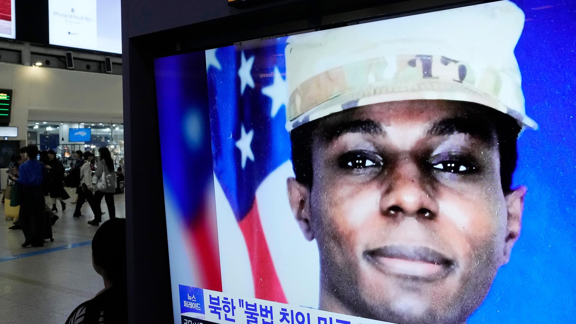Ein Bildschirm in einem Bahnhof in Seoul, Nordkorea, zeigt ein Porträt des US-Soldaten King. Im Hintergrund stehen Menschen auf dem Gleis. Ein Bildschirm in einem Bahnhof in Seoul, Nordkorea, zeigt ein Porträt des US-Soldaten King. Im Hintergrund stehen Menschen auf dem Gleis.