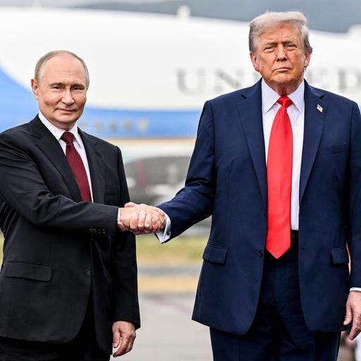 US-Präsident Trump macht einen Hand-Schlag mit Präsident Putin aus Russland. Beide Männer stehen nebeneinander und schauen in Richtung der Kamera.
