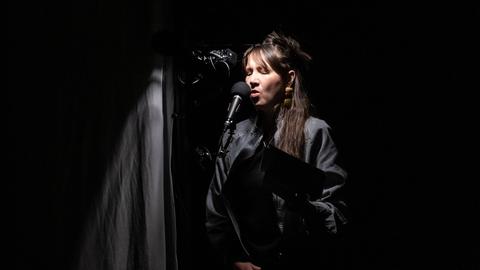 Sophie Hunger steht auf der Leipziger Buchmesse 2025 auf einer Bühne und spricht in ein Mikrofon.