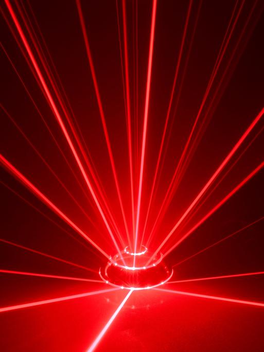 Rote Laserstrahlen leuchten vor schwarzem Hintergrund und ergeben in ihrer Bündelung den Anschein eines Alarmsignals. Rote Laserstrahlen leuchten vor schwarzem Hintergrund und ergeben in ihrer Bündelung den Anschein eines Alarmsignals.