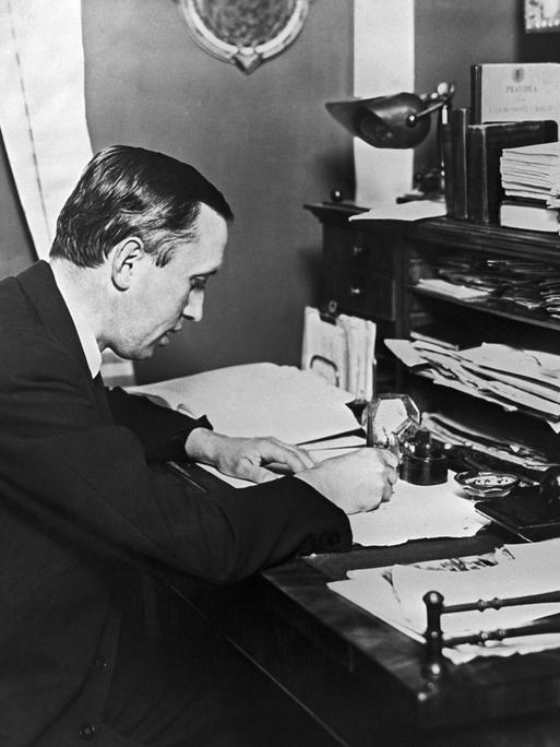 Karel Čapek bei der Arbeit an einem Schreibtisch. Karel Čapek bei der Arbeit an einem Schreibtisch.