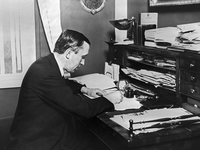 Karel Čapek bei der Arbeit an einem Schreibtisch. Karel Čapek bei der Arbeit an einem Schreibtisch.