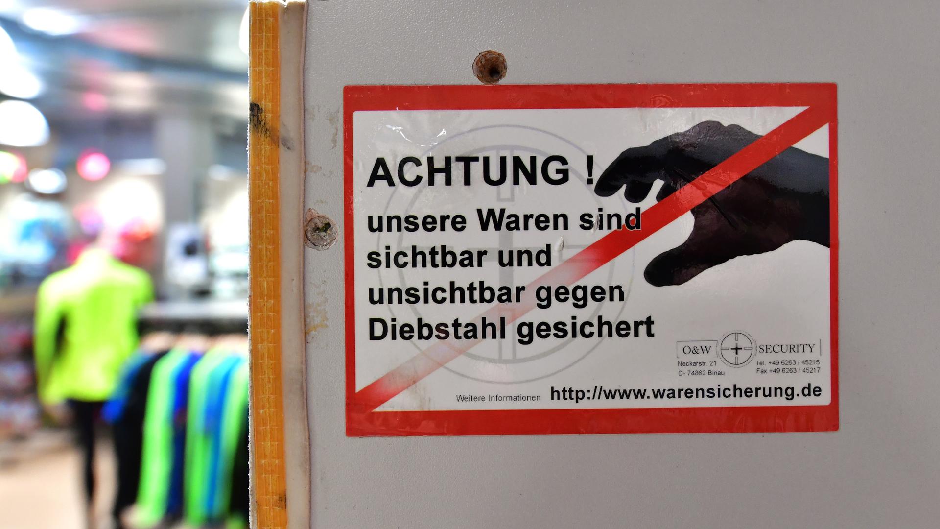 Ein Aufkleber mit der Aufschrift "Achtung ! unsere Waren sind sichtbar und unsichtbar gegen Diebstahl gesichert" ist an der Umkleidekabine in einem Sportgeschäft angebracht. Ein Aufkleber mit der Aufschrift "Achtung ! unsere Waren sind sichtbar und unsichtbar gegen Diebstahl gesichert" ist an der Umkleidekabine in einem Sportgeschäft angebracht.