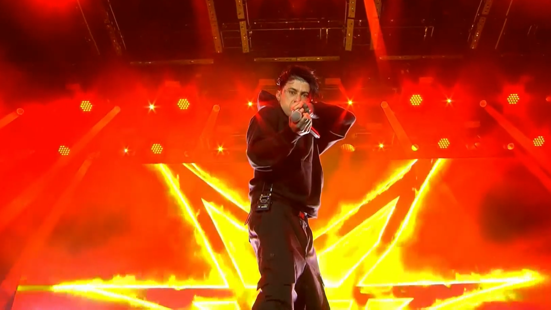 Der Sänger der Band Falling in Reverse steht vor einem rot-gelben Videowand auf der Bühne von Rock am Ring 2025. Der Sänger der Band Falling in Reverse steht vor einem rot-gelben Videowand auf der Bühne von Rock am Ring 2025.