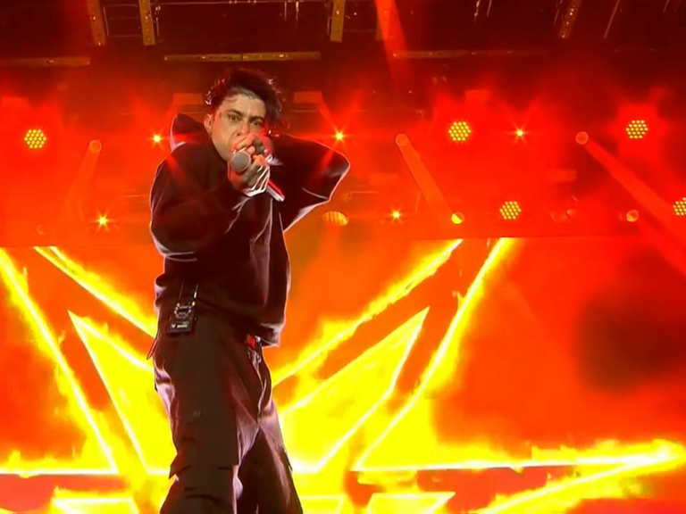 Der Sänger der Band Falling in Reverse steht vor einem rot-gelben Videowand auf der Bühne von Rock am Ring 2025.