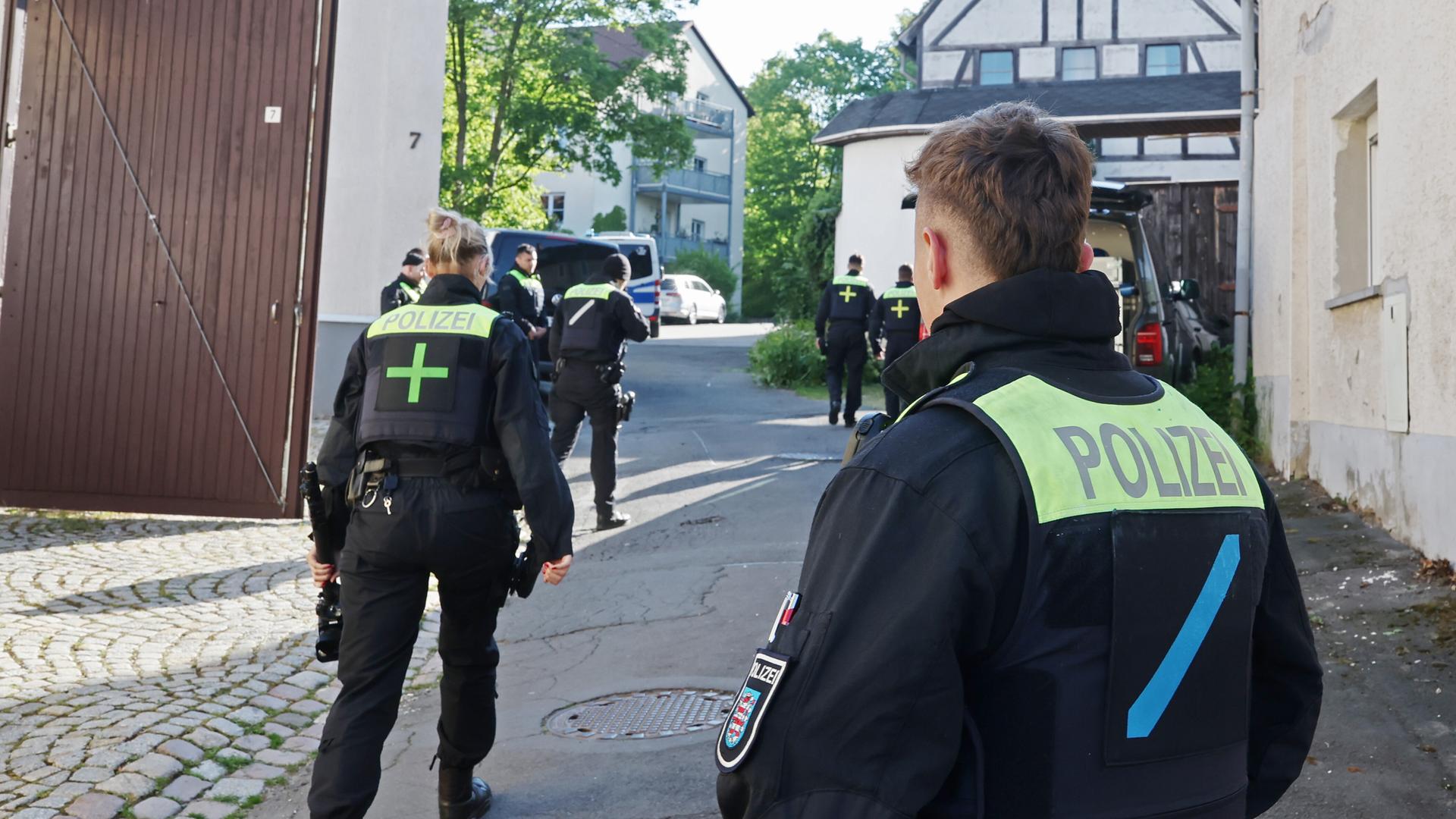 Mehrere Polizeibeamte auf einer Straße in Gera während Gebäude von Mitgliedern der Gruppe "Königreich Deutschland" durchsucht werden
