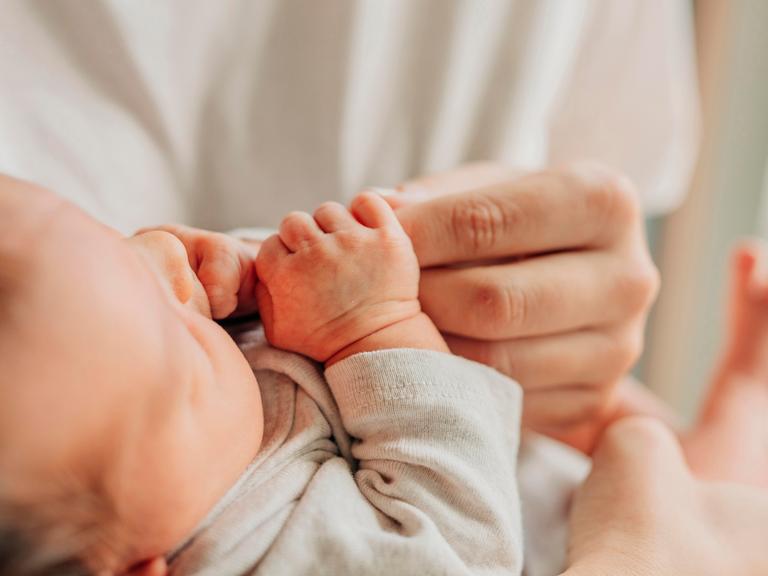 Eine Mutter hält ihr Baby auf dem Arm.