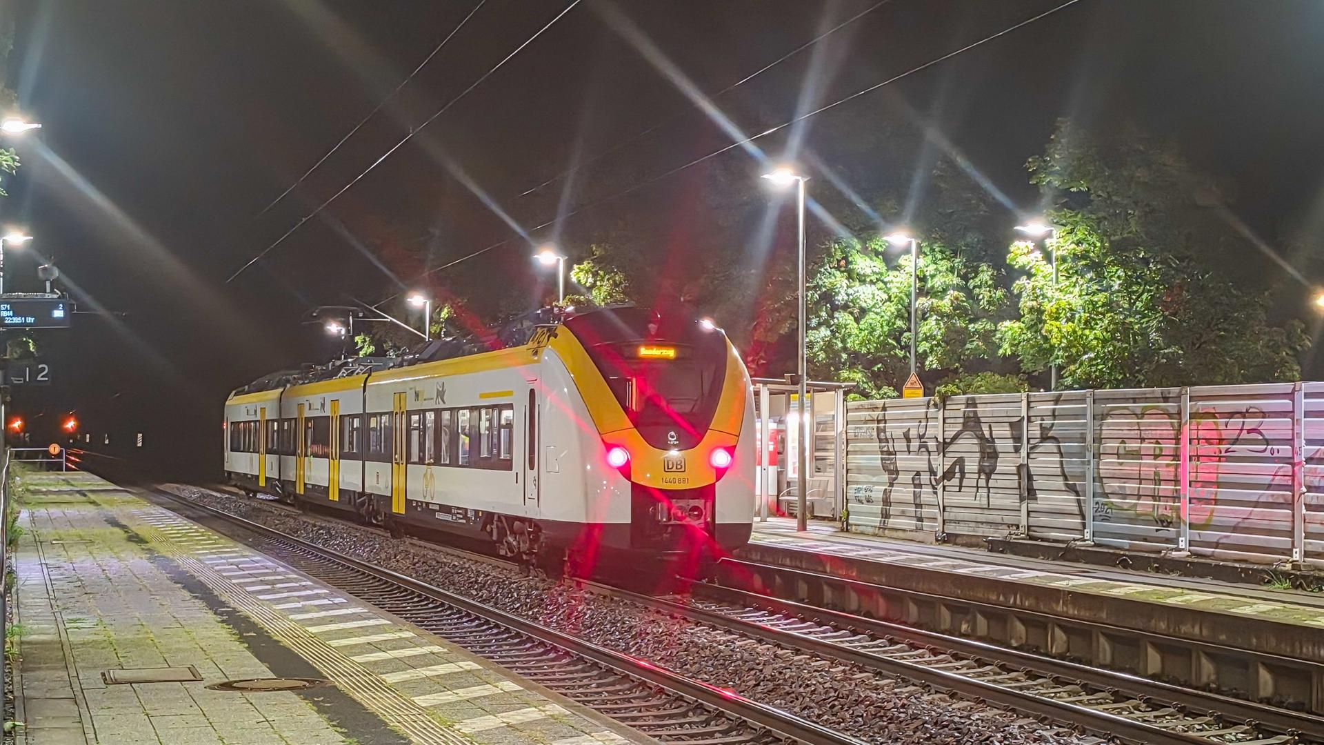 Ein Zug steht an einem Bahnhof auf den Gleisen. Es ist Nacht. Ein Zug steht an einem Bahnhof auf den Gleisen. Es ist Nacht.