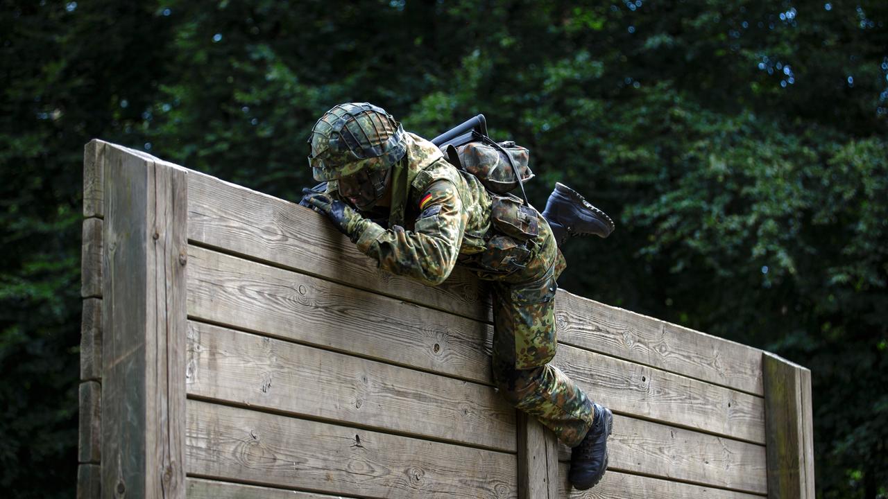 Ein Rekrut der Bundeswehr überwindet auf einem Hindernisparcours Holzlatten. Ein Rekrut der Bundeswehr überwindet auf einem Hindernisparcours Holzlatten.