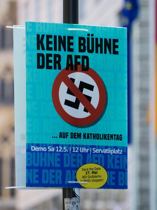 Ein Plakat mit der Aufschrift "Keine Bühne der AfD auf dem Katholikentag" hängt vor dem historischen Rathaus in Münster