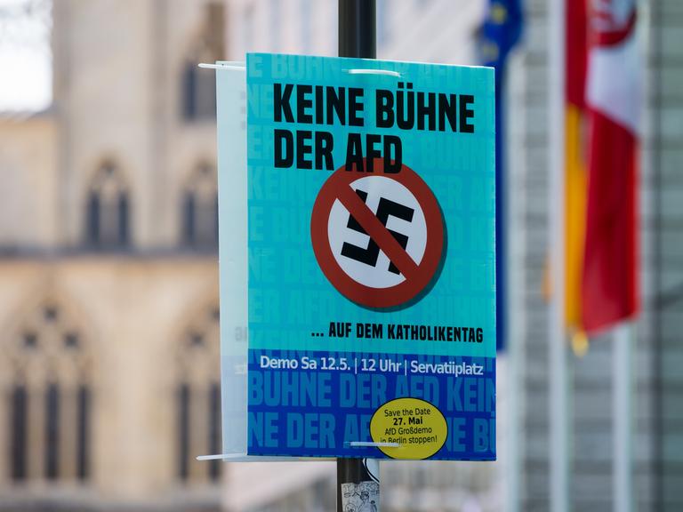 Ein Plakat mit der Aufschrift "Keine Bühne der AfD auf dem Katholikentag" hängt vor dem historischen Rathaus in Münster