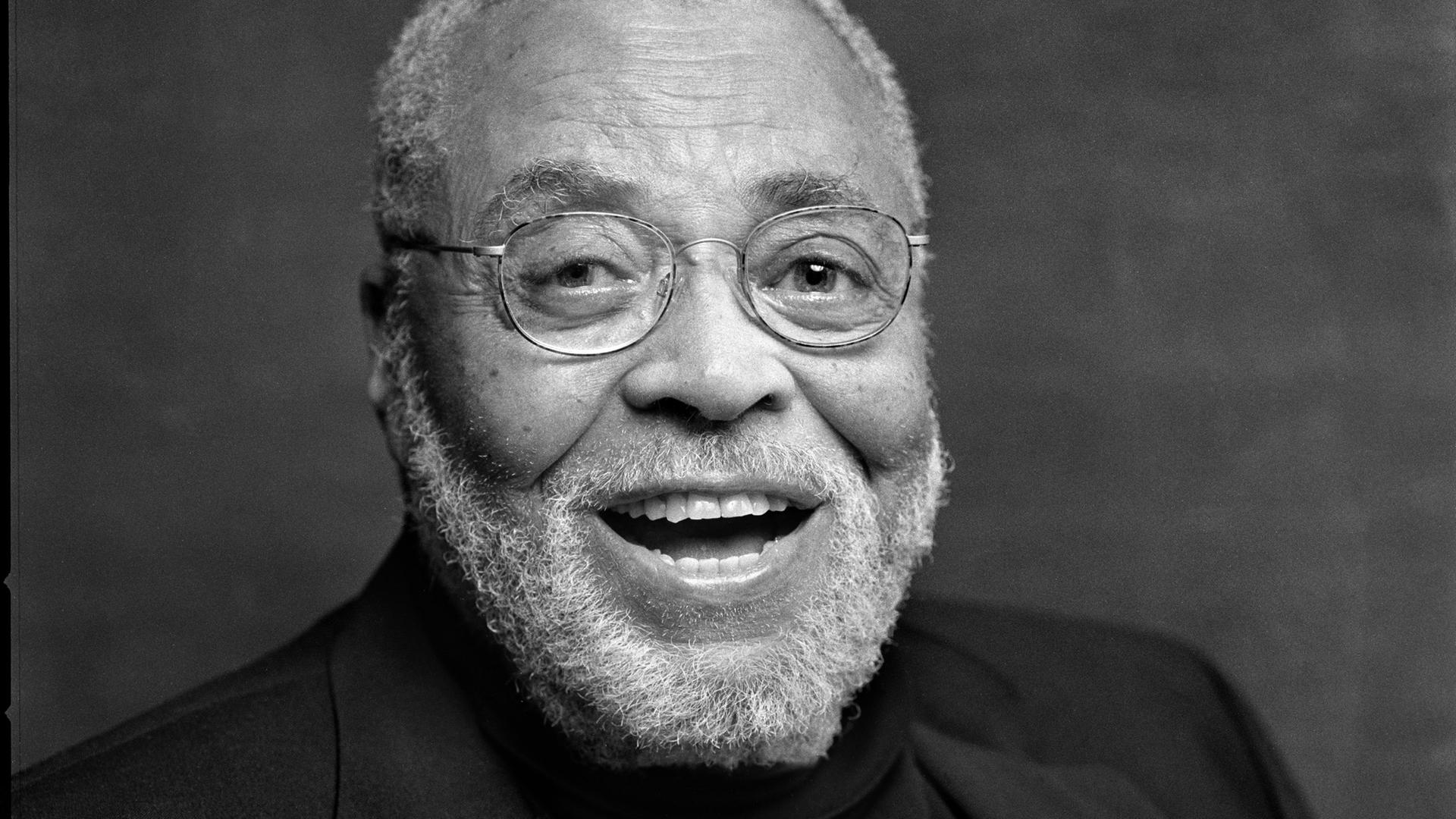 Schwarz-Weiß-Porträt des US-amerikanischen Schauspielers James Earl Jones, der in die Kamera lacht.