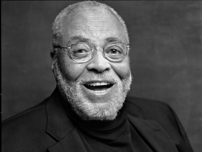 Schwarz-Weiß-Porträt des US-amerikanischen Schauspielers James Earl Jones, der in die Kamera lacht.