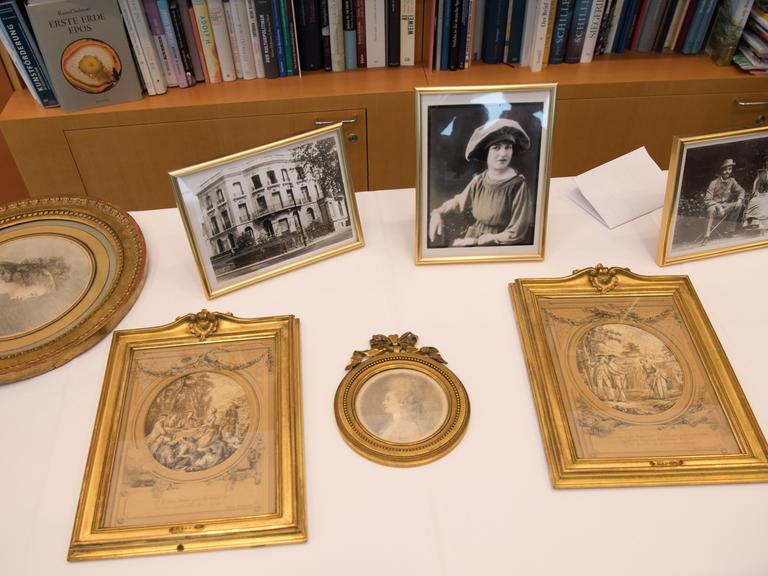 Blick auf vier als NS-Raubkunst identifizierte Zeichnungen, die an die Erben der ursprünglichen Eigentümerin zurückgegeben wurden, und daneben Foto.