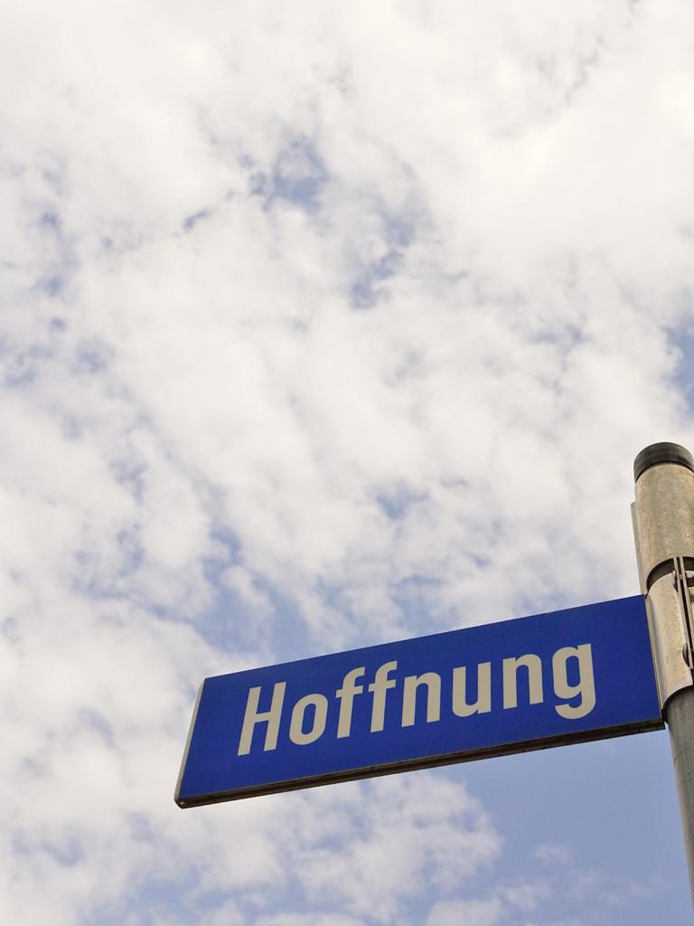 Auf einem Straßenschild ist gegen den Himmel fotografiert "Hoffnung" zu lesen.