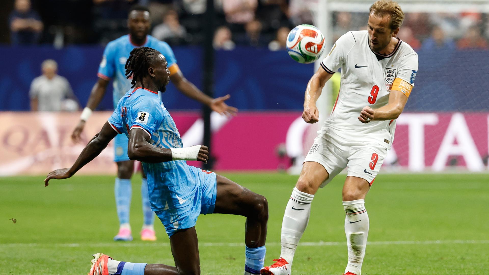 England's Harry Kane (9) und Kongos Ngalayel Mukau kämpfen um den Ball.