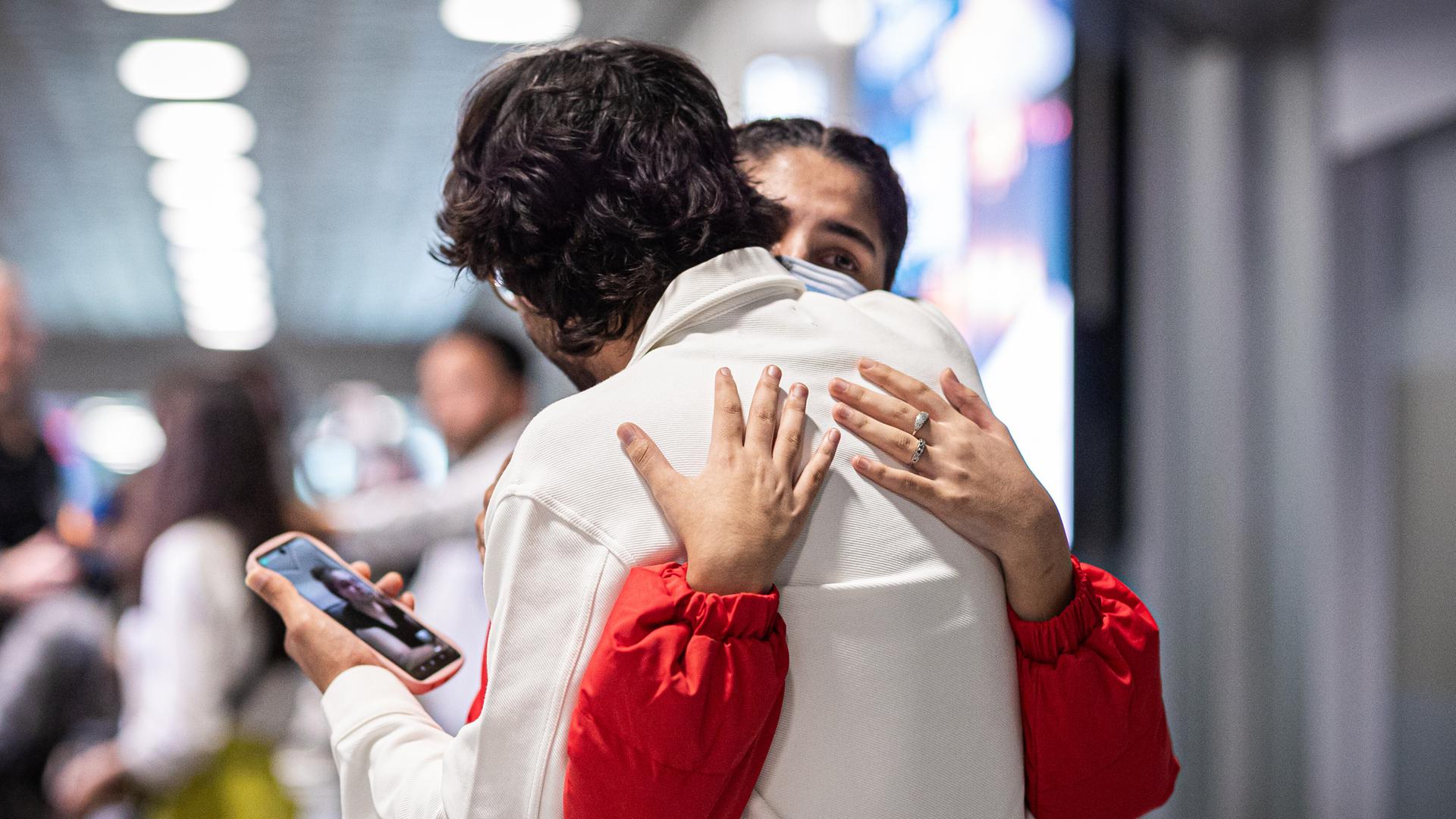 Ein Mann und eine Frau umarmen sich am Flughafen Hannover-Langenhagen. Sie gehören zu einer Gruppe von Menschen aus Afghanistan, die mit deutscher Aufnahmezusage angekommen sind.