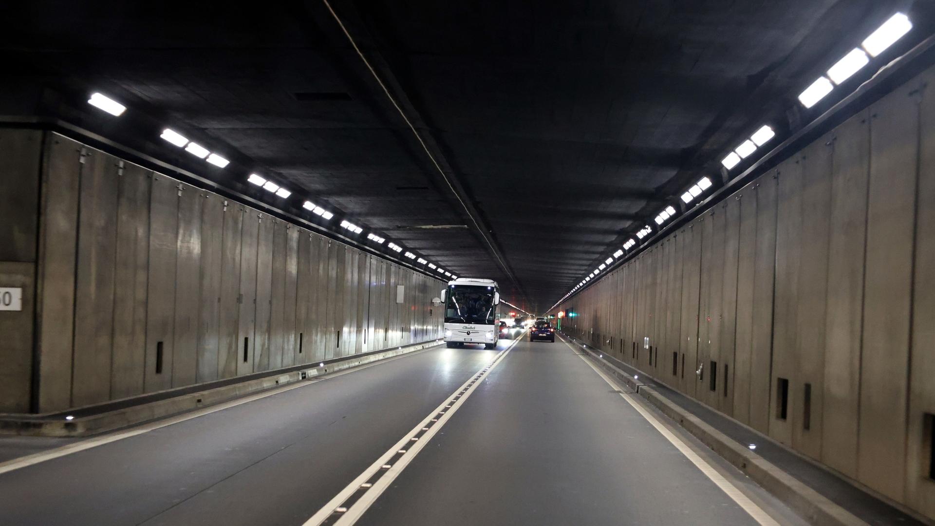 Schweiz: Einige Fahrzeuge und ein Bus fahem im Gotthard-Tunnel.