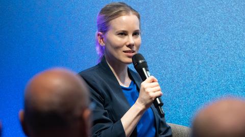 Die Journalistin und Autorin Julia Ruhs, eine Frau mit Jackett und blonden, eng zusammengebundenen Haaren, spricht bei einer Diskussionsveranstaltung "Debatte erwünscht? Meinungsvielfalt und Medienkultur" in der Hermann-Ehlers-Akademie. 