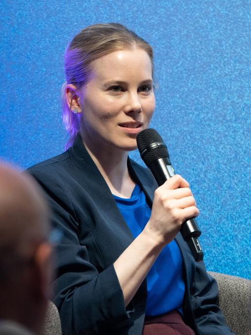 Die Journalistin und Autorin Julia Ruhs, eine Frau mit Jackett und blonden, eng zusammengebundenen Haaren, spricht bei einer Diskussionsveranstaltung "Debatte erwünscht? Meinungsvielfalt und Medienkultur" in der Hermann-Ehlers-Akademie.  Die Journalistin und Autorin Julia Ruhs, eine Frau mit Jackett und blonden, eng zusammengebundenen Haaren, spricht bei einer Diskussionsveranstaltung "Debatte erwünscht? Meinungsvielfalt und Medienkultur" in der Hermann-Ehlers-Akademie.