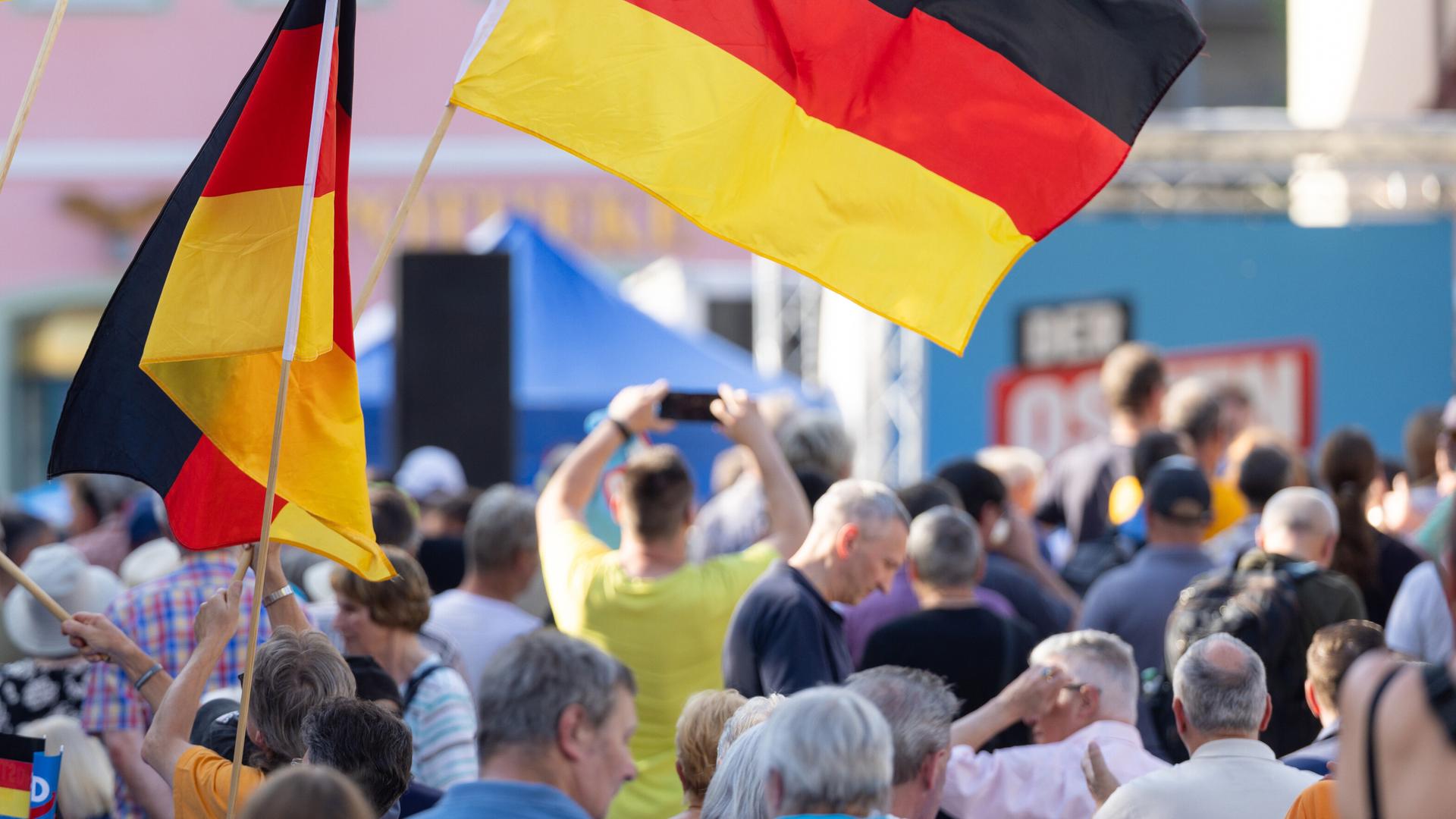 Zuschauer schwenken Deutschlandfahnen beim Wahlkampf der AfD Thüringen auf dem Marktplatz. Zuschauer schwenken Deutschlandfahnen beim Wahlkampf der AfD Thüringen auf dem Marktplatz.