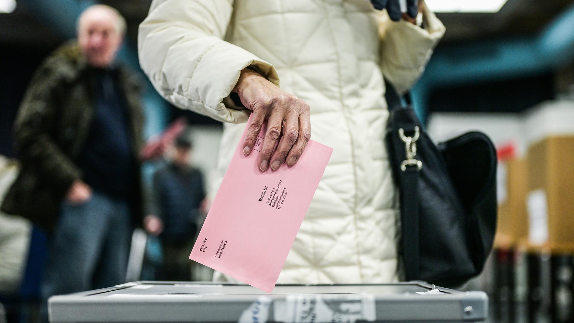 Eine Hand wirft die Wahlunterlagen in die Wahlurne im Briefwahl vor Ort Raum im Rathaus Bochum am Dienstag, 11. Februar 2025. (Symbolfoto)