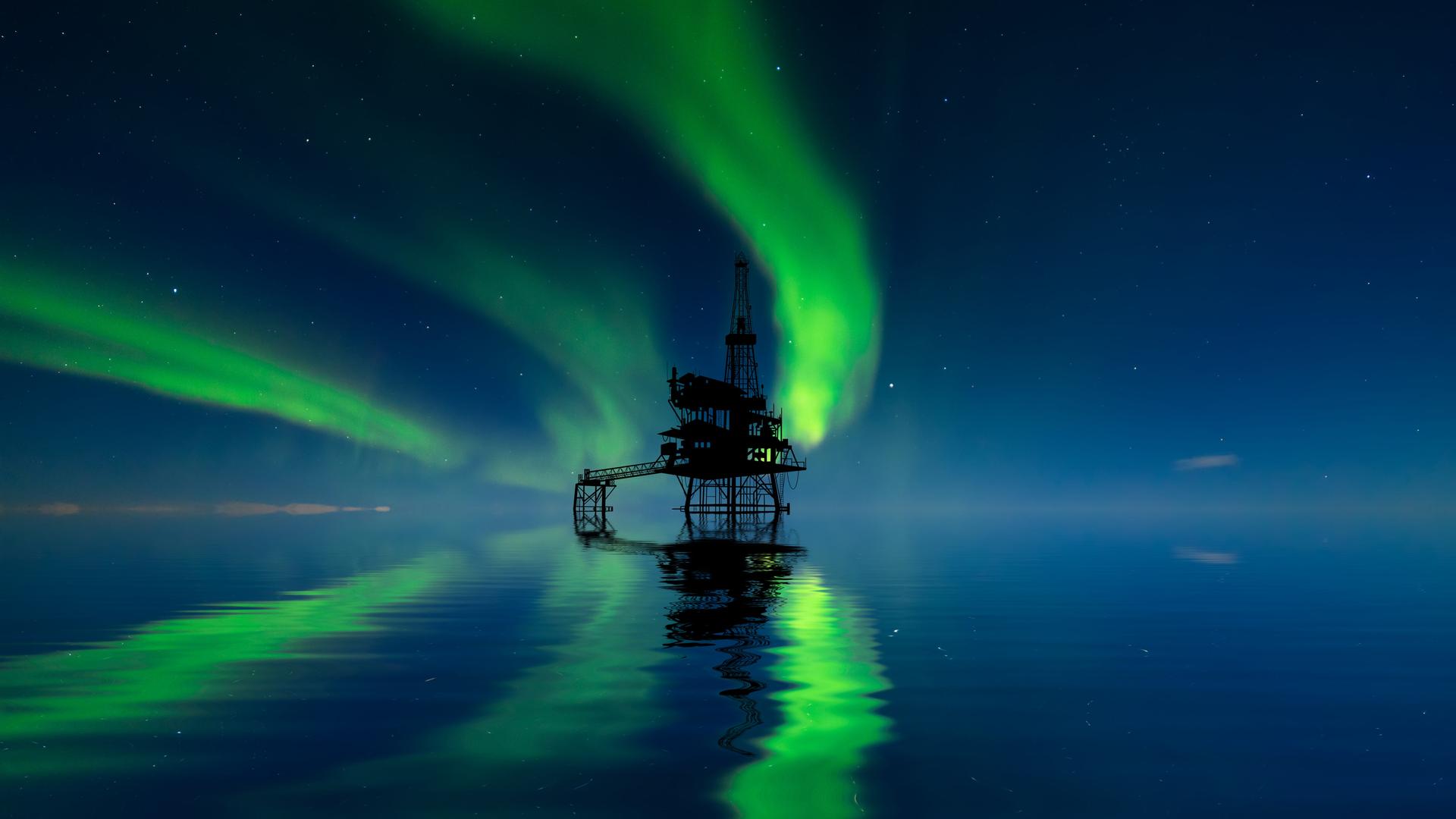 Eine Ölplattform in der Arktis mit Nordlichtern am Himmel.