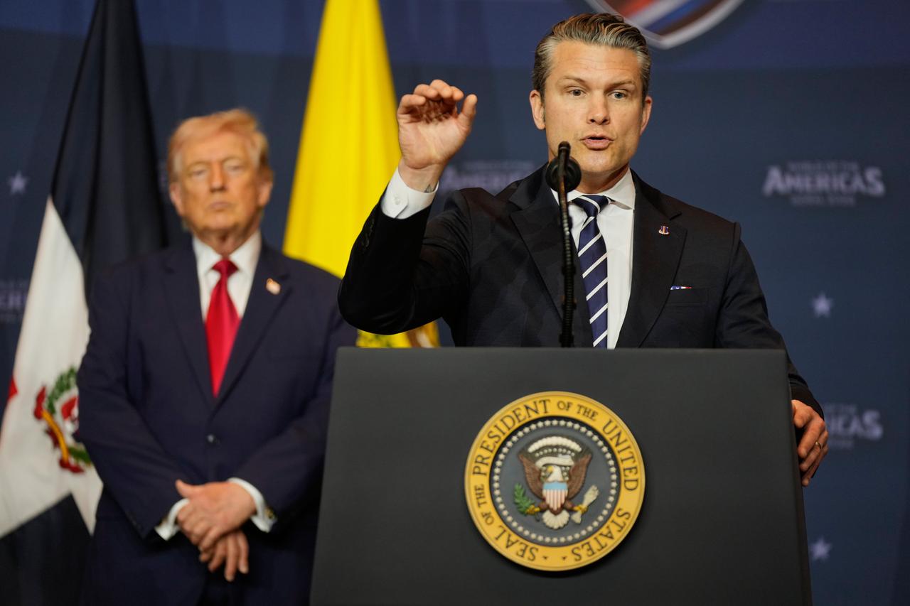 US-Verteidigungsminister Pete Hegseth spricht an einem Rednerpult. Im Hintergrund ist Donald Trump und die US-Flagge zu sehen. US-Verteidigungsminister Pete Hegseth spricht an einem Rednerpult. Im Hintergrund ist Donald Trump und die US-Flagge zu sehen.