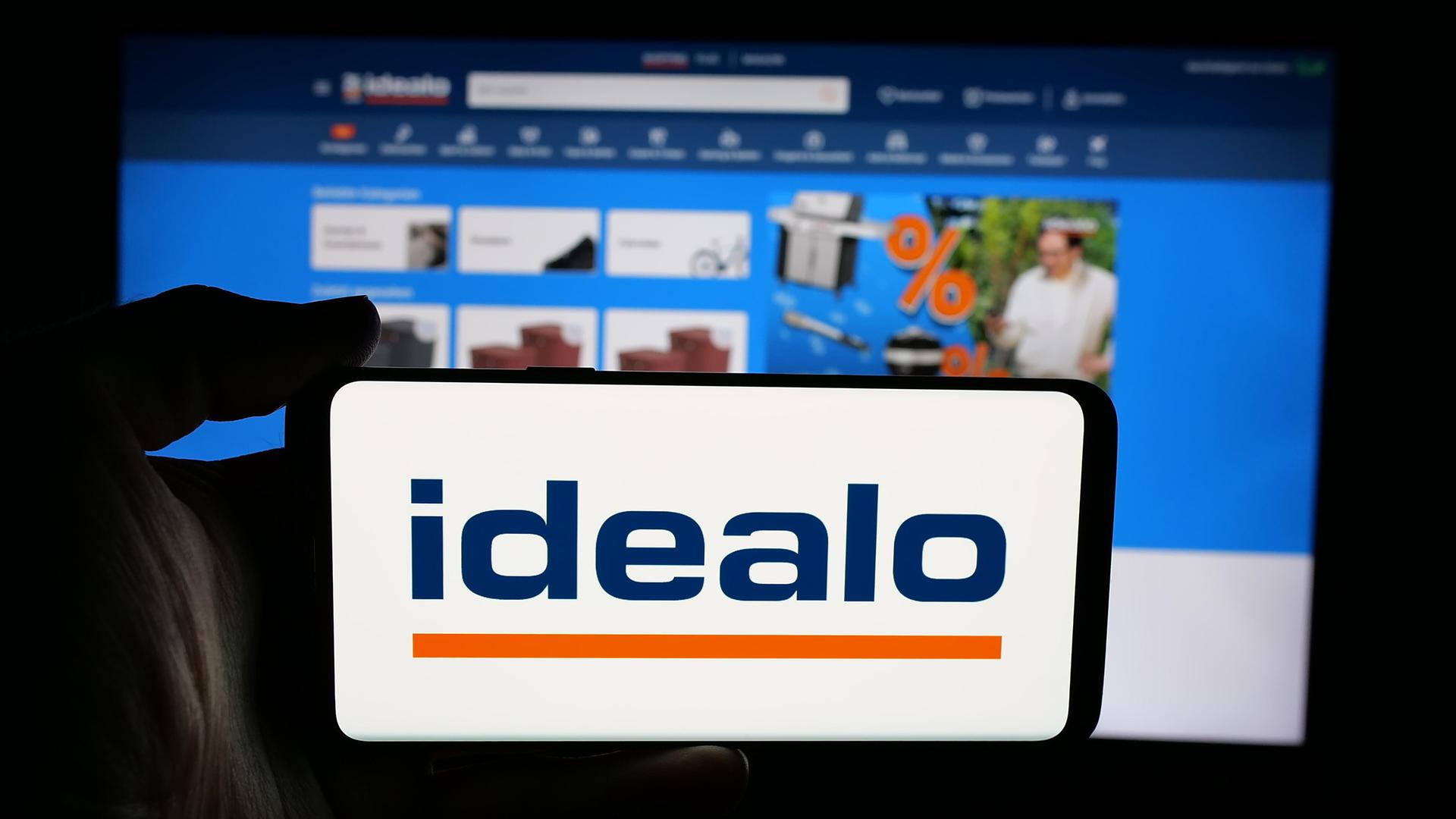 Im Vordergrund das Idealo-Logo, dahinter verschwommen die Website.