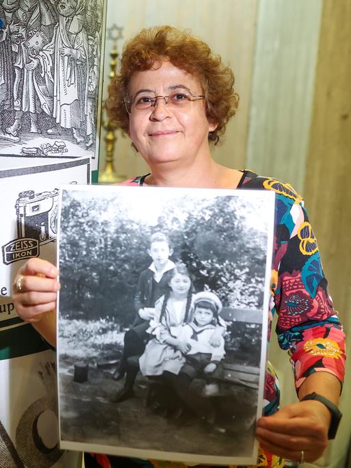 Nadia Vergne mit einem Schwarz-weiß-Foto ihrer Familie in der Hand.