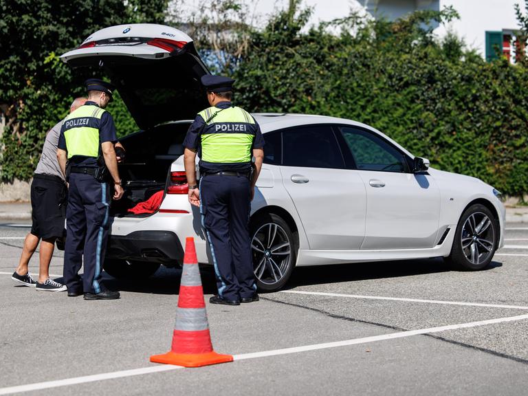 Gestelltes Bild aus Pressetermin: Grenzpolizisten schauen in den Kofferraum eines Autos.