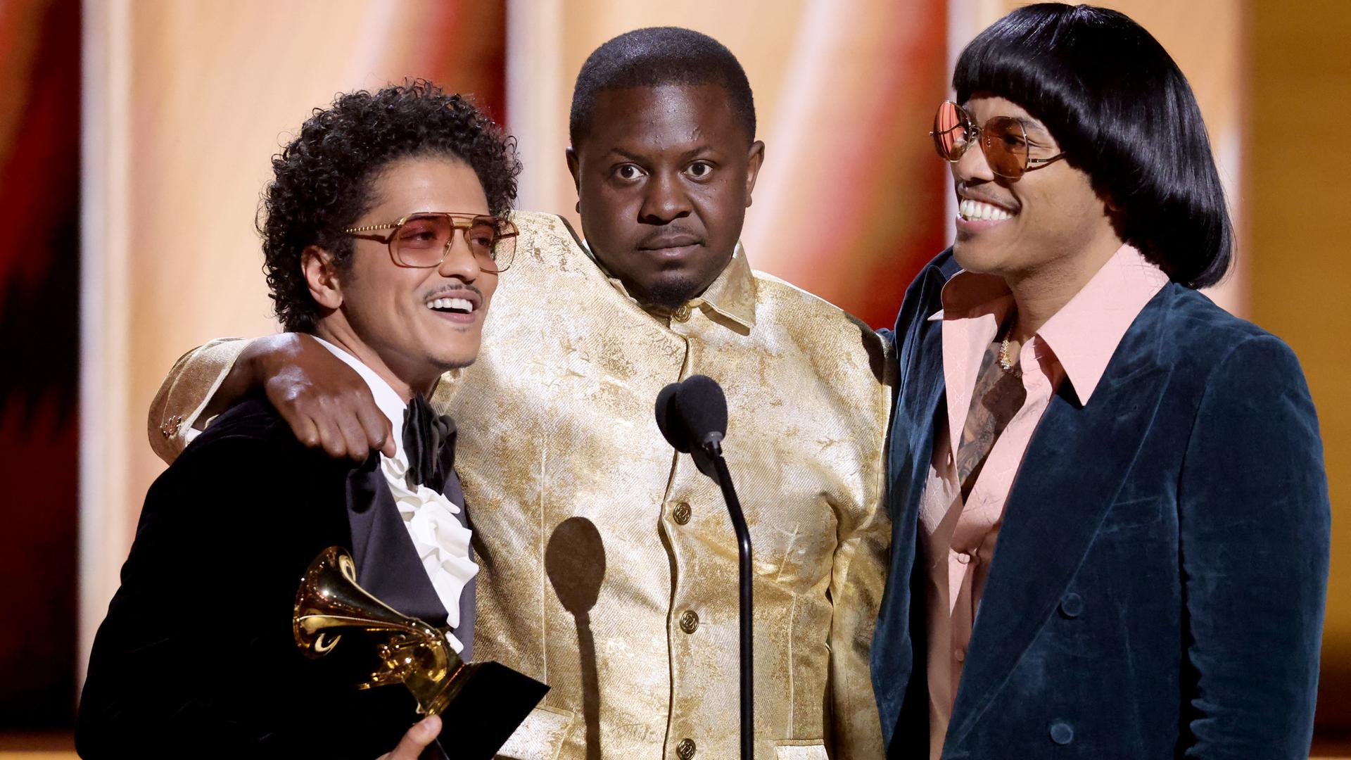 Bruno Mars, Dernst Emile II, und Anderson Paak von Silk Sonic nehmen den Grammy entgegen. Bruno Mars, Dernst Emile II, und Anderson Paak von Silk Sonic nehmen den Grammy entgegen.