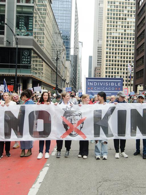 In Chicago halten mehrere Demonstranten ein großes Banner mit der Aufschrift "No Kings" am 14.6.2025.
