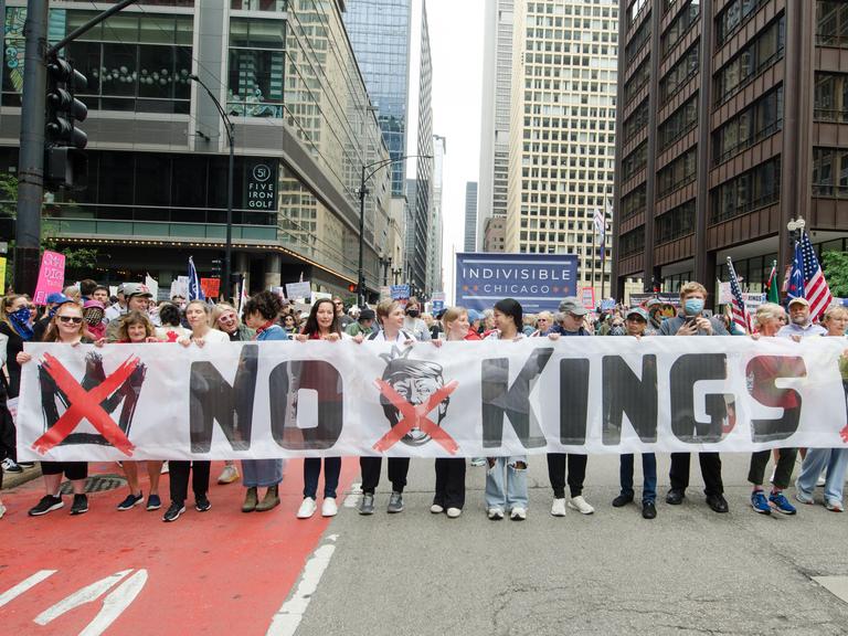 In Chicago halten mehrere Demonstranten ein großes Banner mit der Aufschrift "No Kings" am 14.6.2025.