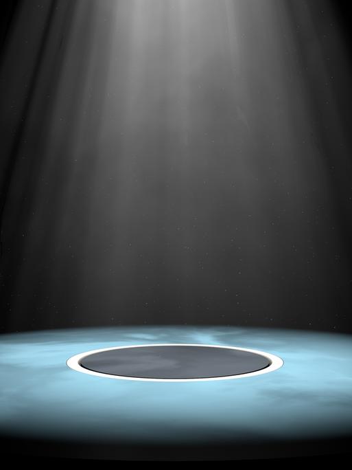 Auf einer Theaterbühne wird ein Kreis in der Mitte mit einem Spotlight bestrahlt.