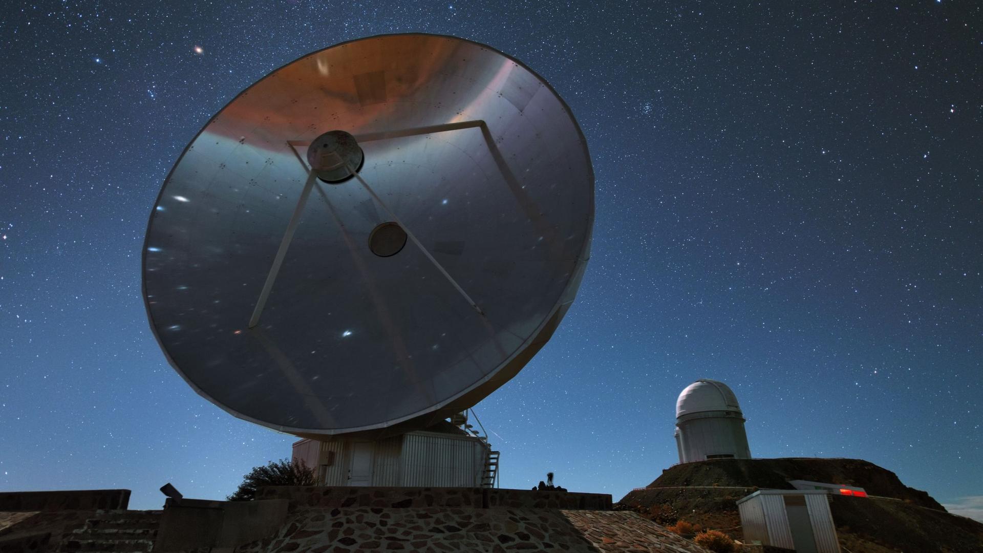 This is the Swedish-ESO Submillimetre Telescope (SEST) which was decommissioned in 2003. Its 15-metre diameter dish is silently towering over the La Silla landscape. In the background you can see the ESO 3.6-metre telescope, which has been in operation since 1987. This is the Swedish-ESO Submillimetre Telescope (SEST) which was decommissioned in 2003. Its 15-metre diameter dish is silently towering over the La Silla landscape. In the background you can see the ESO 3.6-metre telescope, which has been in operation since 1987.