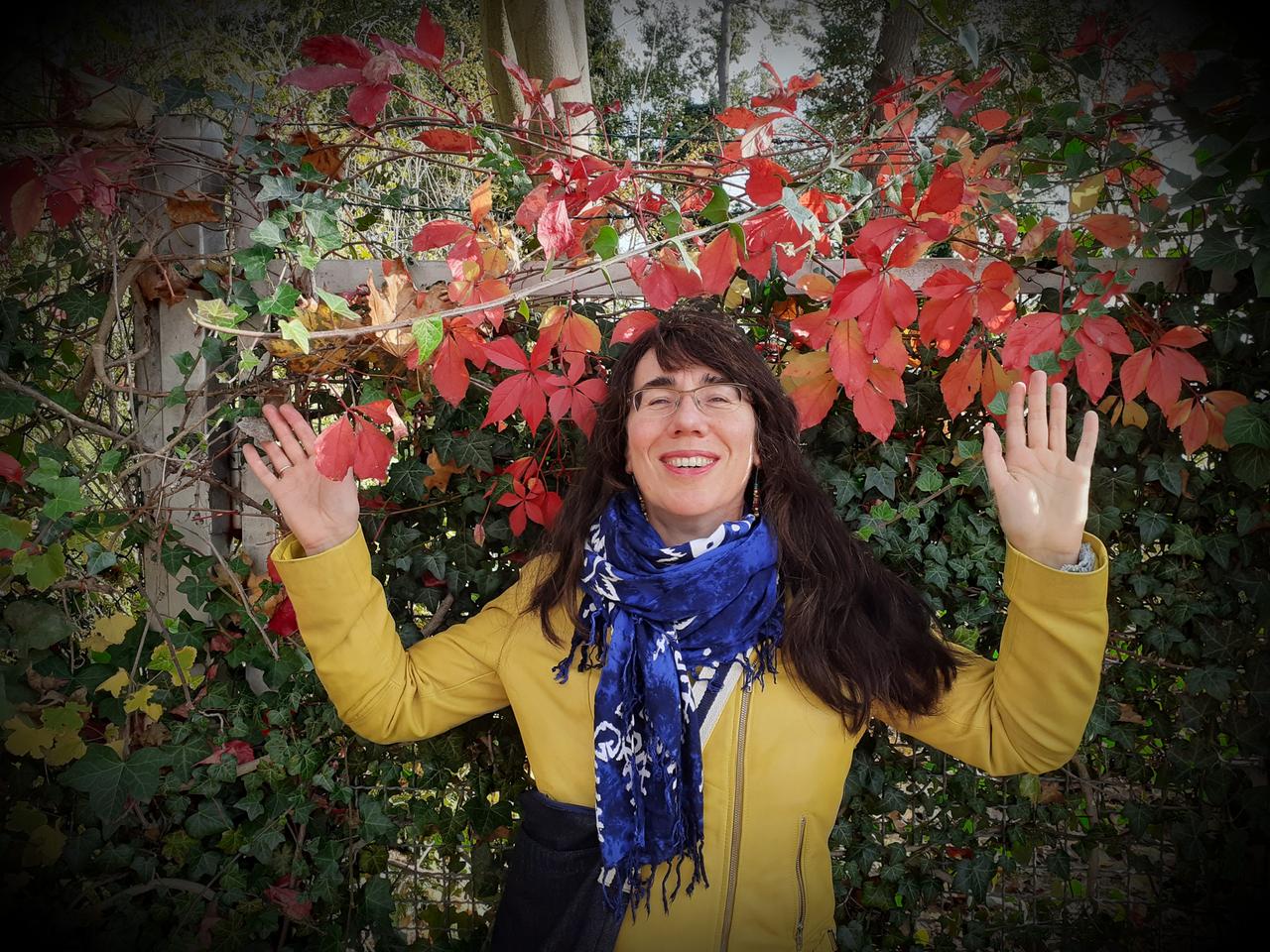 Cornelia Sachse vor mit Herbstlaub umrahmten Zaun.