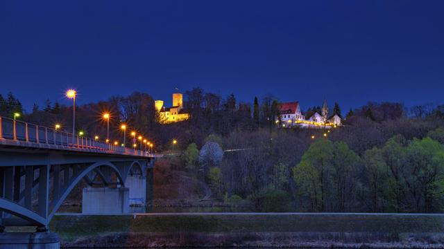 Blick auf Grünwald mit Grünwalder Burg und Grünwalder Brücke bei Nacht.