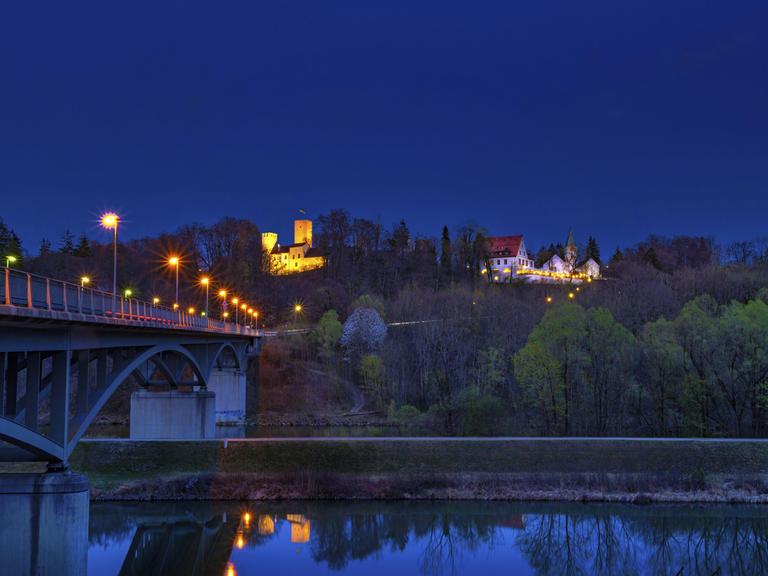 Blick auf Grünwald mit Grünwalder Burg und Grünwalder Brücke bei Nacht.