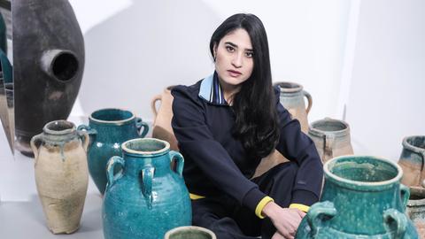 Porträt der aus dem Iran stammenden Galeristin Anahita Sadighi am 10. Dezember 2022 in Berlin Charlottenburg. Sie sitzt in einem Atelier artigen Raum zwischen großen Keramikvasen und blickt aufmerksam in die Kamera Porträt der aus dem Iran stammenden Galeristin Anahita Sadighi am 10. Dezember 2022 in Berlin Charlottenburg. Sie sitzt in einem Atelier artigen Raum zwischen großen Keramikvasen und blickt aufmerksam in die Kamera