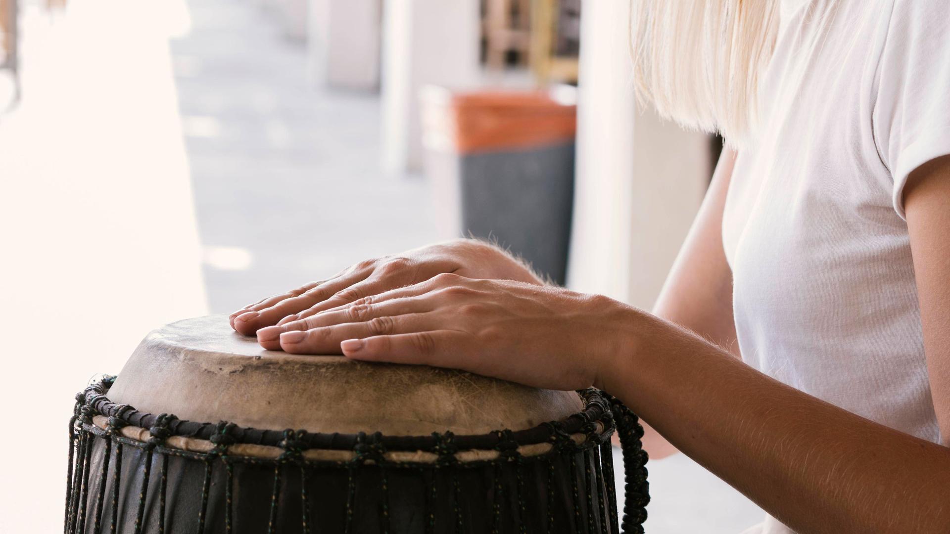 Junge Person spielt eine Trommel