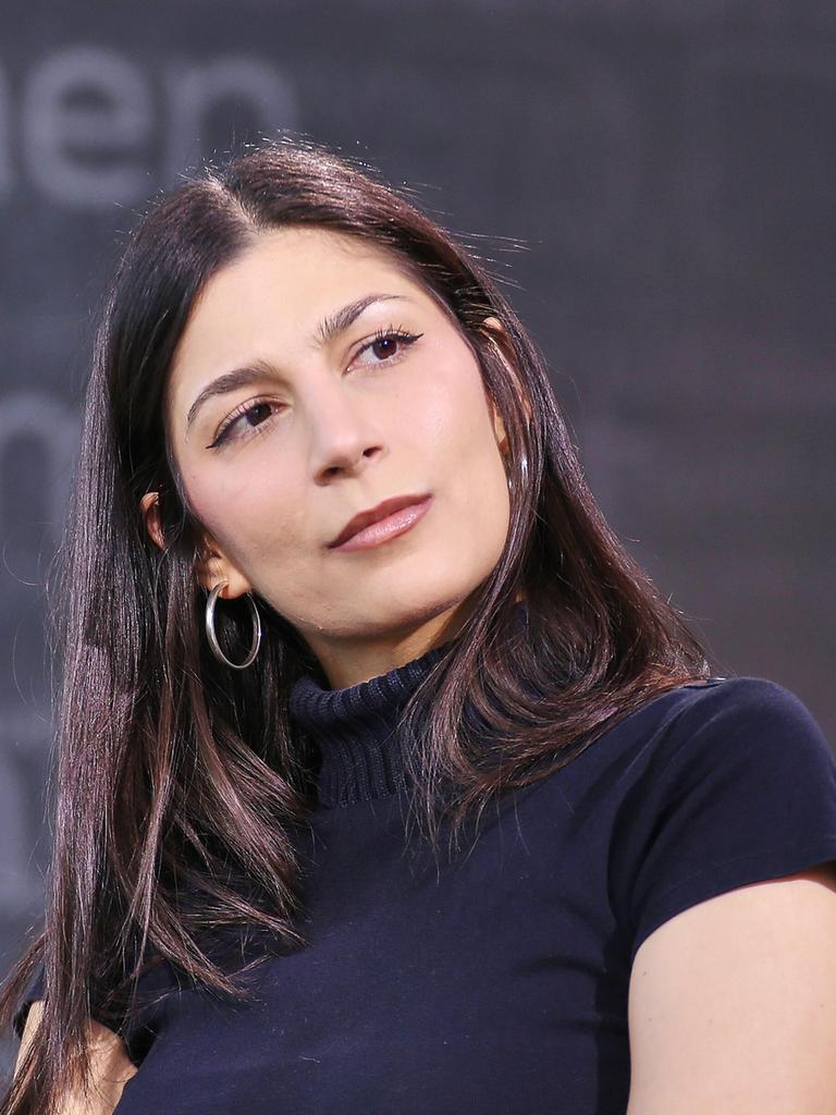 Miriam Davoudvandi trägt ein schwarzes Rollkragen-T-Shirt und hat den Kopf zur Seite geneigt.
