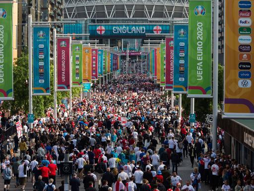 Viele Menschen laufen auf das Wembley-Stadion zu. Dort fand das Halbfinal-Spiel der Fußball-EM 2020 statt. 