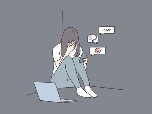 Eine farbige Zeichnung zeigt ein Mädchen, das niedergeschlagen auf dem Boden sitzt und auf ihrem Smartphone Nachrichten liest. In einer Sprachblase ist "Loser" zu lesen. Symbolbild für Cybermobbing