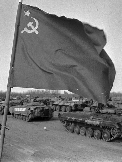 Sowjetische Truppen verlassen 1989 Afghanistan. Über einem Panzer weht die sowjetische Flagge. 