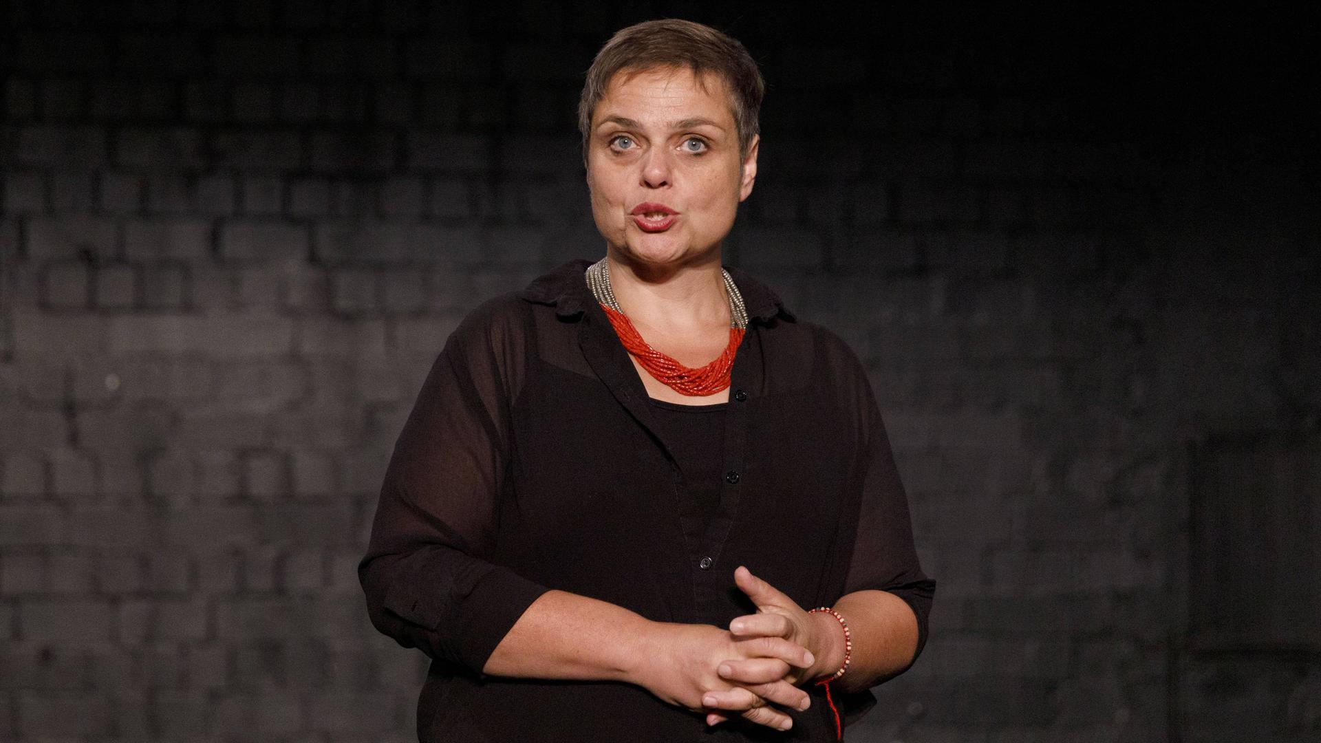 Bettina Montazem beim Pressetermin zu ""Das Sherlock Musical" im Urania Theater in Köln Ehrenfeld in dunkler Kleidung vor dunklem Hintergrund. 