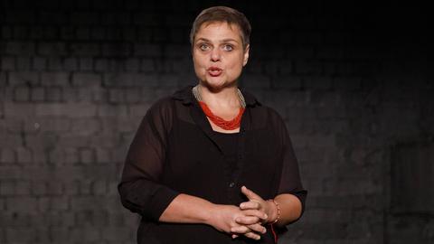 Bettina Montazem beim Pressetermin zu ""Das Sherlock Musical" im Urania Theater in Köln Ehrenfeld in dunkler Kleidung vor dunklem Hintergrund. 